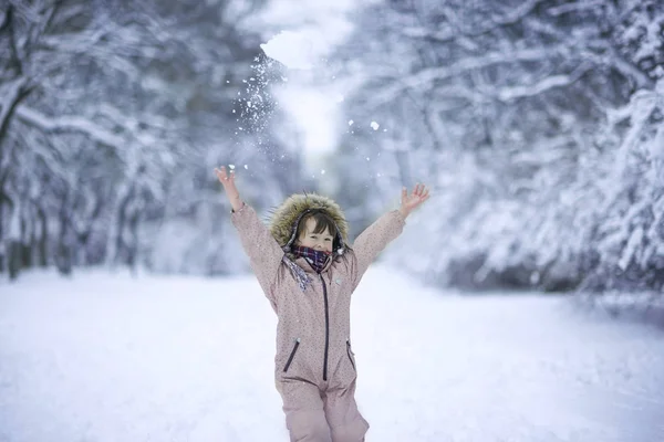 Little girl enjoy first snow in the park