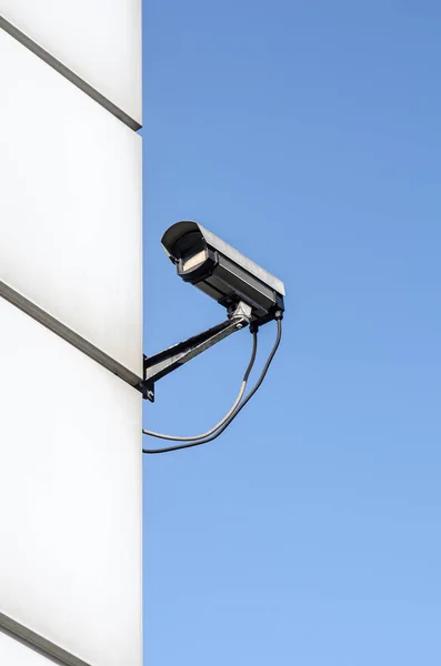 Vigilancia de vigilancia de la cámara de seguridad en una esquina de la casa con cielo azul —  Fotos de Stock
