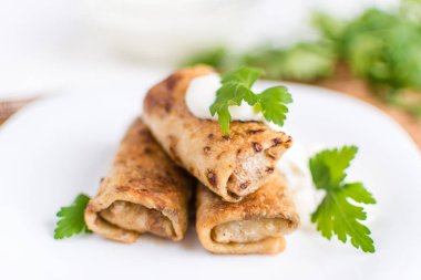 Beyaz bir tabağa dolması etli krep dolu