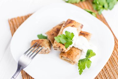 Beyaz bir tabağa dolması etli krep dolu