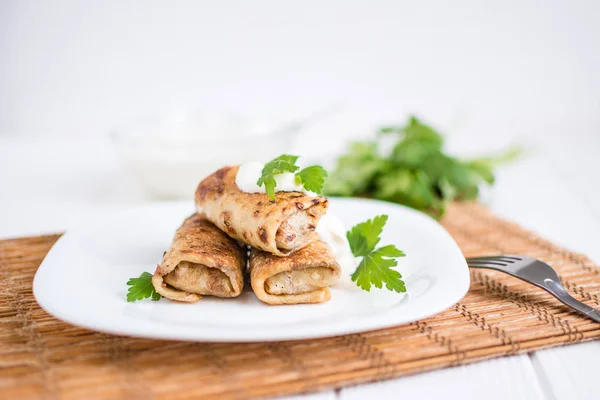 Beyaz bir tabağa dolması etli krep dolu