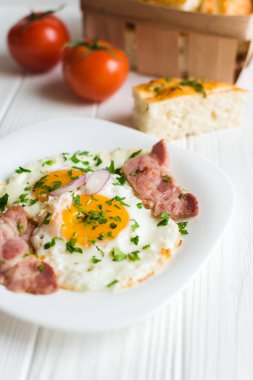 Beyaz arka planda pastırmalı sahanda yumurta. 