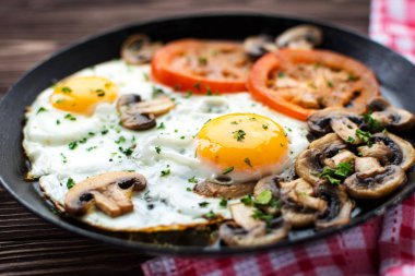 Kızarmış yumurta mantar ve koyu ahşap masa üzerinde domates 