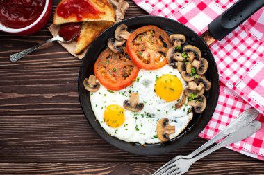 Kızarmış yumurta mantar ve koyu ahşap masa üzerinde domates 