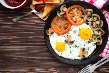 Kızarmış yumurta mantar ve koyu ahşap masa üzerinde domates 