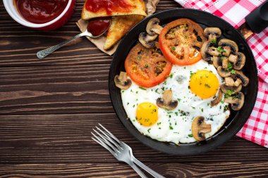 Kızarmış yumurta mantar ve koyu ahşap masa üzerinde domates 