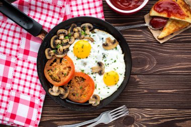 Kızarmış yumurta mantar ve koyu ahşap masa üzerinde domates 