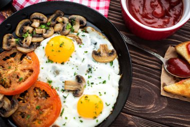 Kızarmış yumurta mantar ve koyu ahşap masa üzerinde domates 