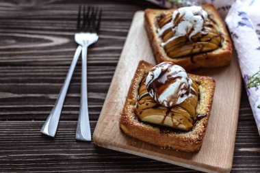 Tost ve rustik bir arka plan üzerinde dondurma ile pişmiş elma 