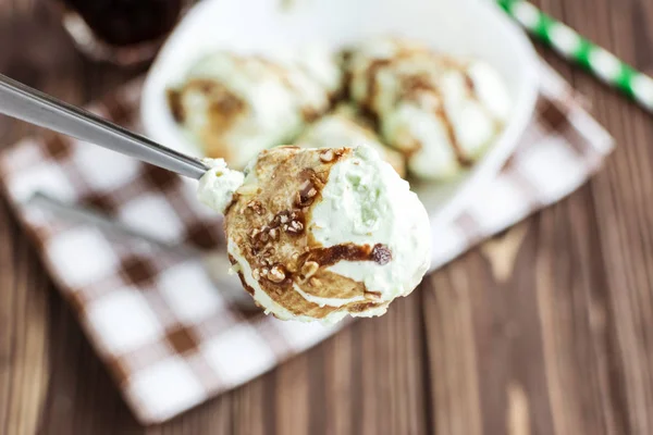 Pistachio ice cream with chocolate on a rustic background — Stock Photo, Image