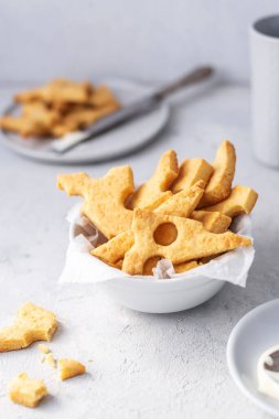 Peynirli kraker, tuzlu atıştırmalık konsepti. Kurabiyeler, gri arka planda bir parça peynir.