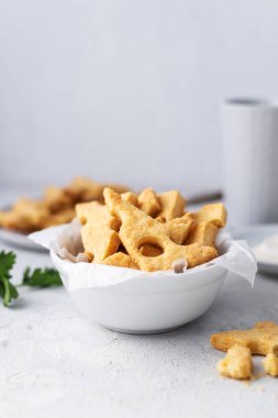 Peynirli kraker, tuzlu atıştırmalık konsepti. Kurabiyeler, gri arka planda bir parça peynir.