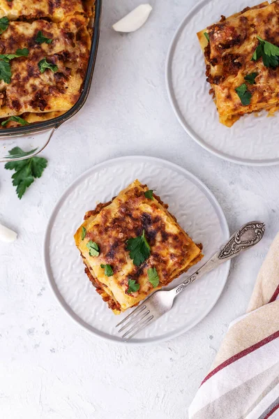Gri arka planda Bachamel soslu ev yapımı İtalyan lazanyası. Peynirli sıcak lazanya.