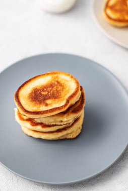Krepler. Gri arka planda ballı krep yığını. Ev yapımı kahvaltı.