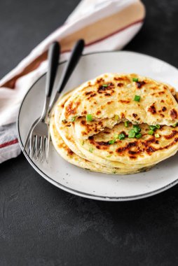 Siyah arka planda Çin usulü leziz soğanlı krep. Bir yığın kızarmış yeşil soğanlı krep. Siyah fotoğraf