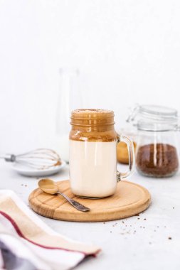 Beyaz arka planda bardakta son moda dalgona kahvesi. Kore kahveli ve köpüklü kahve içiyor. Yeni popüler yiyecek ve içecek trendi. Seçici odak