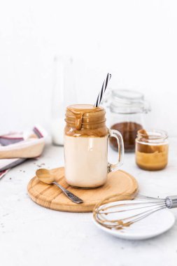 Beyaz arka planda bardakta son moda dalgona kahvesi. Kore kahveli ve köpüklü kahve içiyor. Yeni popüler yiyecek ve içecek trendi. Seçici odak