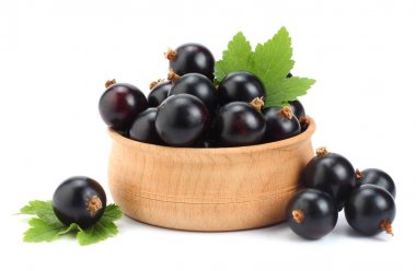 ahşap kase yeşil yaprak üzerinde beyaz izole Siyah frenk üzümü