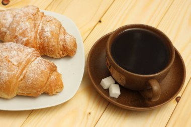 ahşap üzerine kahve ile taze kruvasan