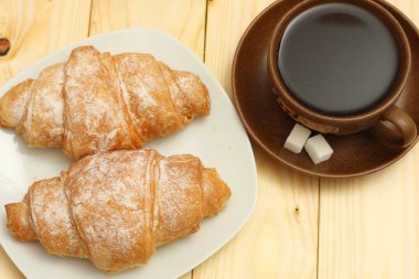 ahşap üzerine kahve ile taze kruvasan