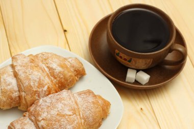 ahşap üzerine kahve ile taze kruvasan