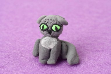 Pembe arka planda plastik kedi. Kil modelleme