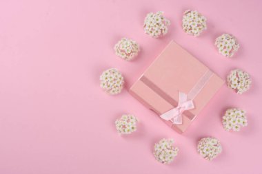 Pembe arka planda bahar beyaz çiçekleri. Düz yatış, üst görünüm.