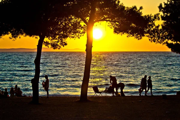 Le persone silhouette sulla spiaggia al tramonto — Foto Stock