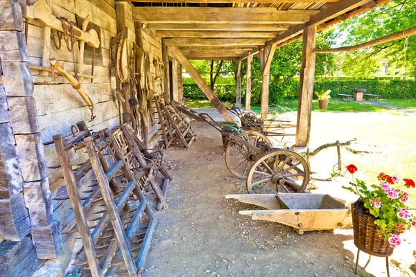 Traditional wooden cottage and agricultural tools in rural regio — Stock Photo, Image