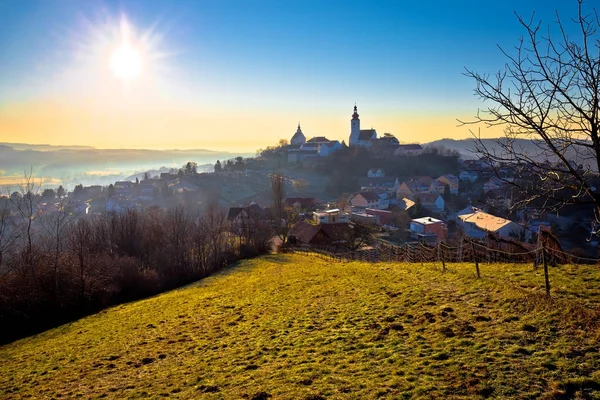 Straden villaggio in nebbia chiesa sulla collina — Foto Stock