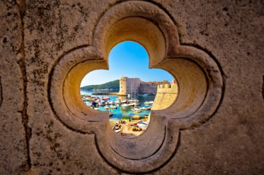 Dubrovnik harbor view from Ploce gate through stone carved detai clipart