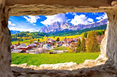 Beautiful landscape of Cortina d' Ampezzo in Dolomites Alps view through stone window, Veneto region of Italy clipart