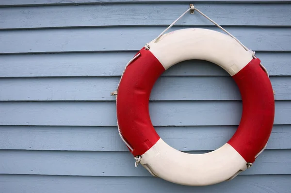 Red and White Lifebuoy on a Blue Background Stock Photo