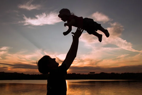 父亲和日落时的小女儿轮廓。 — 图库照片
