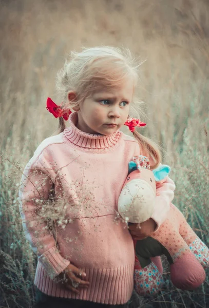 Adorable sad girl with hourse toy in park — Stock Photo, Image