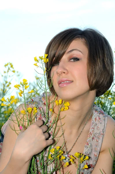 Menina bonita ao ar livre no campo com flores — Fotografia de Stock