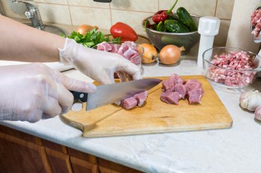 Bir kadın bir ahşap kesme tahtası üzerinde taze domuz kesiyor