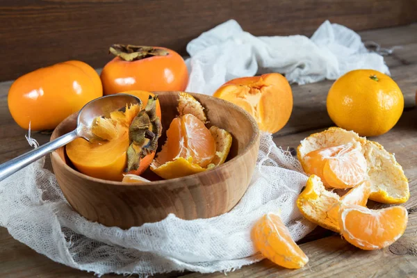 Caquis y mandarinas frescas en tazón —  Fotos de Stock