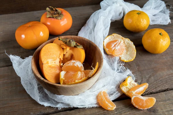 Caquis y mandarinas frescas en tazón —  Fotos de Stock