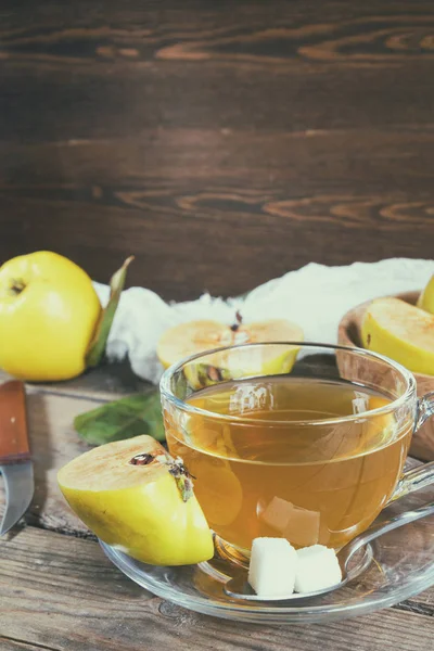 Cup of hot  tea and fresh quince fruit on table — Stock Photo, Image