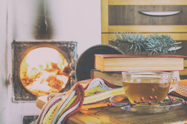 Cup of tea and flames of fire in a fireplace