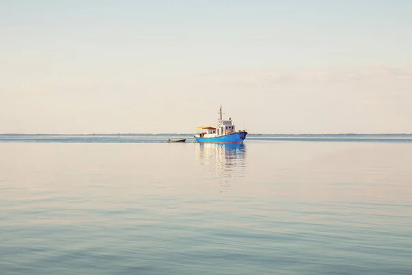 Синій старий старовинний річковий човен на спокійних водах — стокове фото