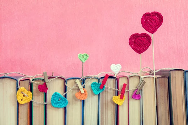 De nombreux coeurs de crochet multicolore sur les livres — Photo