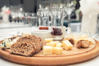 Ahşap yuvarlak tahta üzerinde farklı lezzetli peynir