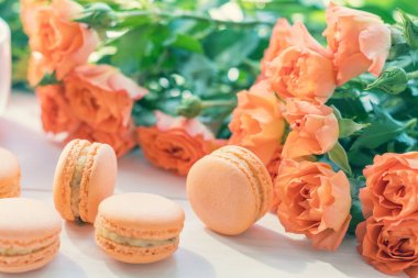 Turuncu macaroons ve taze küçük güller