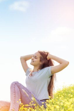 Sarı çiçekli bir çim alan genç kız