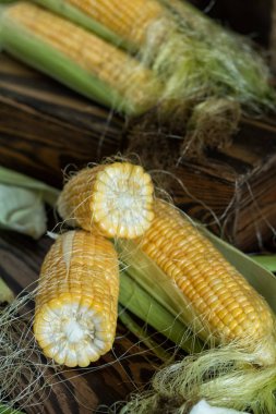 Taze tatlı mısır koçanı rustik ahşap masada üzerinde yakın çekim. Tonda