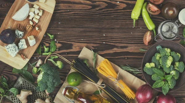 Verduras orgánicas frescas y artículos de cocina sobre fondo de madera . — Foto de Stock