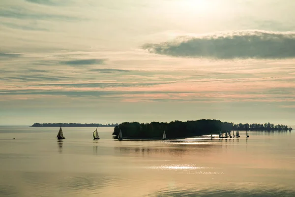 Auringonnousu joen yli jahdit tyynellä veden pinnalla — kuvapankkivalokuva