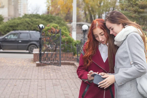 Duas adolescentes do sexo feminino à procura de notícias no smartphone em t — Fotografia de Stock